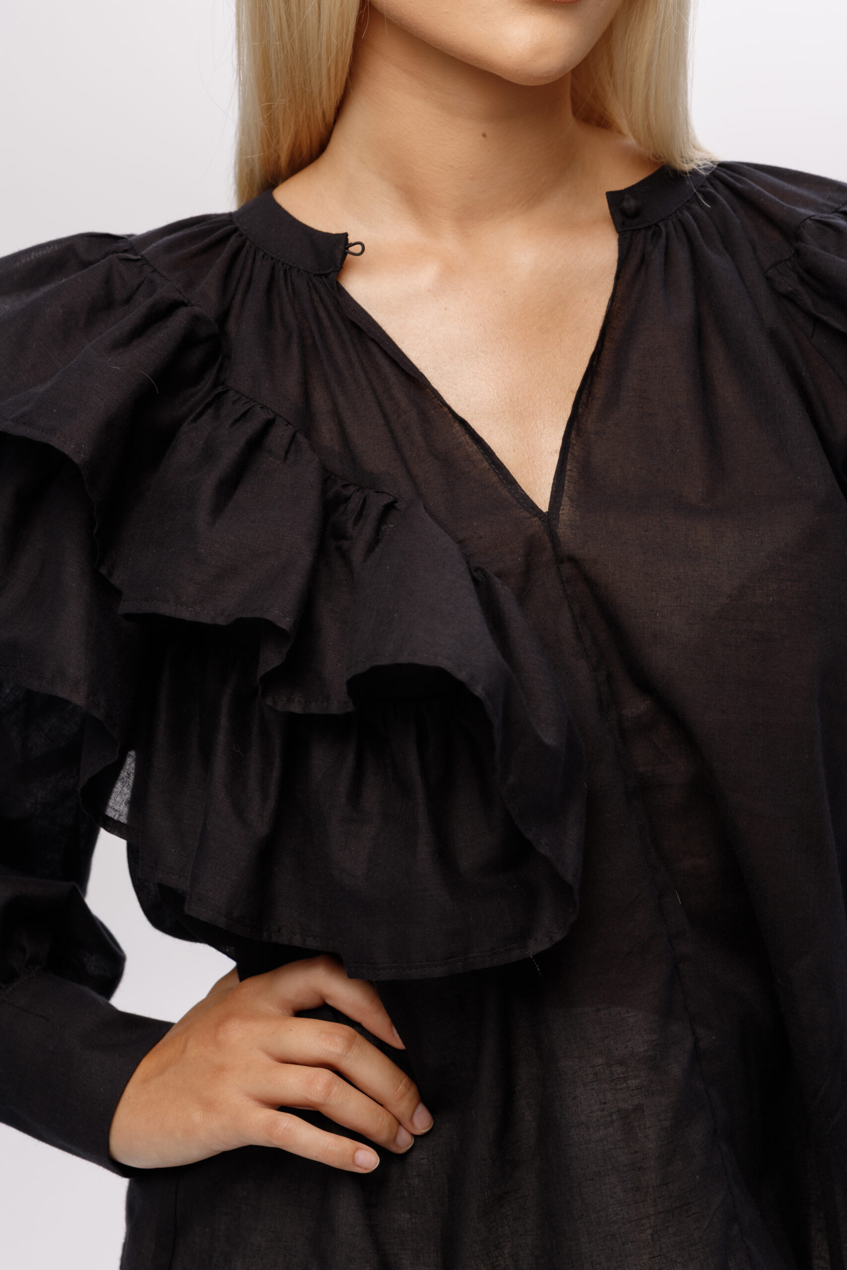 Bluzka „Aurora” – detal przodu z falbaną i dekoltem, czarna bawełna