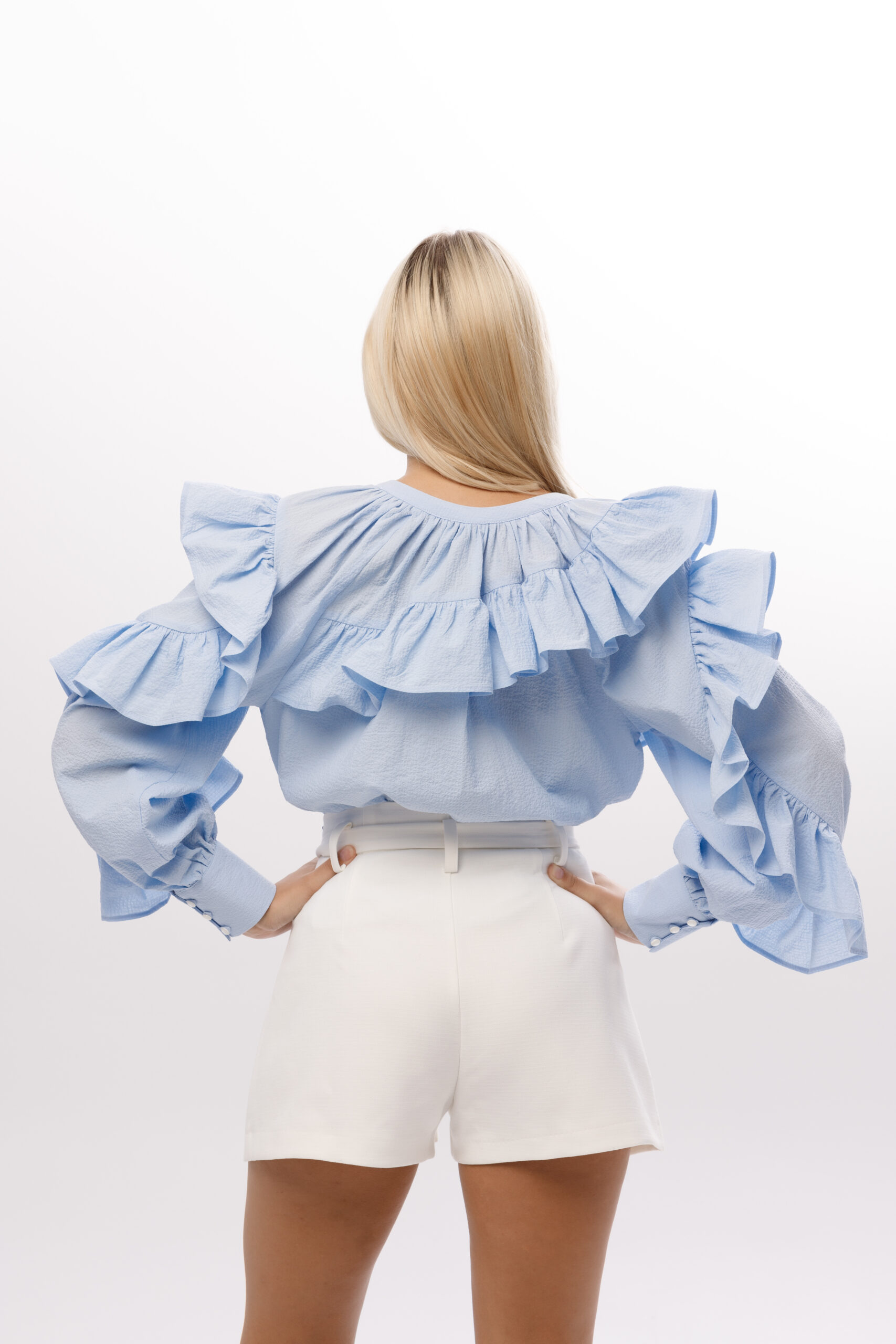 Bluzka „Celeste” – widok z tyłu, dekoracyjne falbany na plecach i ramionach, błękitny kolor